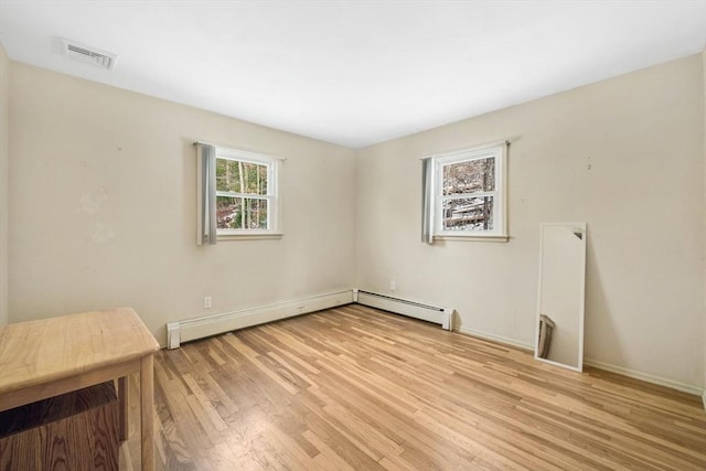 unfurnished room featuring light wood-type flooring and a baseboard radiator