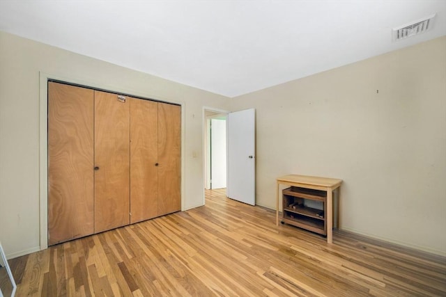 unfurnished bedroom featuring a closet and light hardwood / wood-style flooring