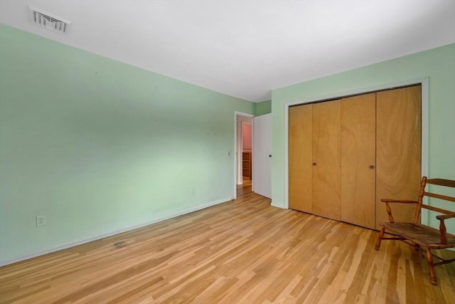 unfurnished bedroom featuring a closet and light hardwood / wood-style floors