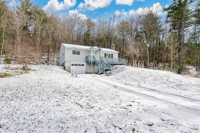 snow covered rear of property with a garage