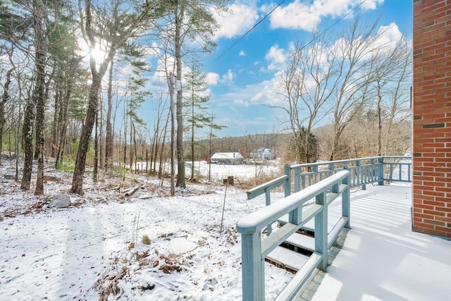 yard layered in snow with a wooden deck