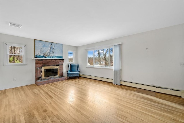 unfurnished living room with a fireplace, light wood-type flooring, and a baseboard radiator