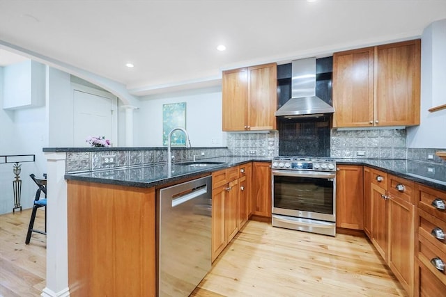44 Dartmouth St Unit 1, Boston, MA 02116 - kitchen featuring light wood-type flooring, a sink, a peninsula, stainless steel appliances, and wall chimney exhaust hood