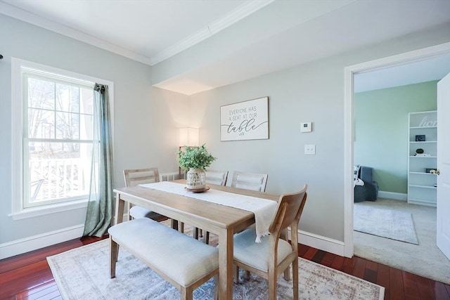 dining space featuring dark wood-type flooring, crown molding, and a healthy amount of sunlight