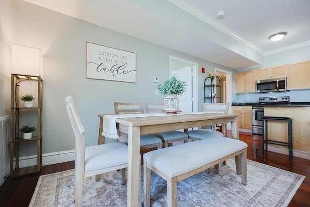 dining room featuring dark wood-type flooring and crown molding