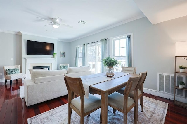 dining room featuring ceiling fan, dark wood-type flooring, and crown molding