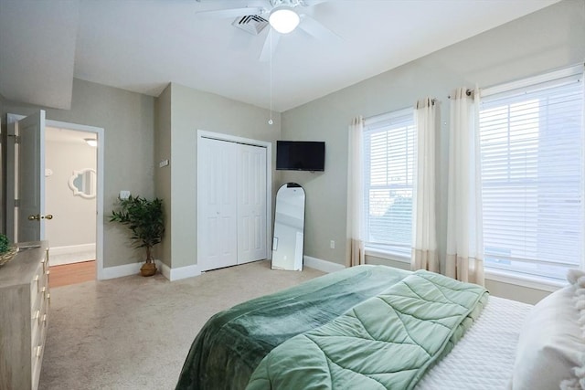 bedroom featuring ceiling fan, a closet, and light colored carpet