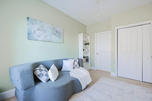 carpeted bedroom featuring ceiling fan and a closet