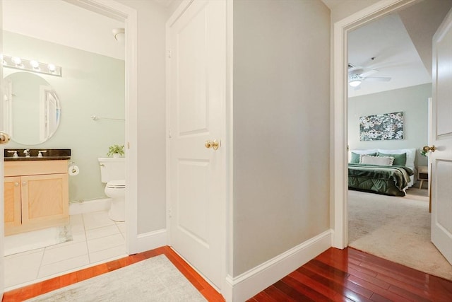 bathroom featuring ceiling fan, hardwood / wood-style floors, toilet, and vanity