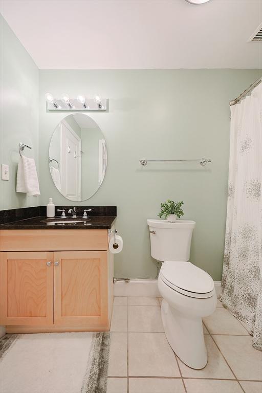 bathroom featuring toilet, vanity, and tile patterned flooring