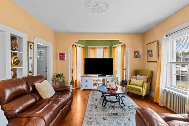 209 Grove St, Brockton, MA 02302 - living area with radiator heating unit, wood finished floors, and arched walkways