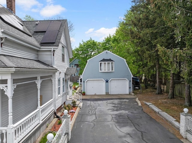 209 Grove St, Brockton, MA 02302 - view of property exterior with a garage, a shingled roof, a gambrel roof, roof mounted solar panels, and an outbuilding