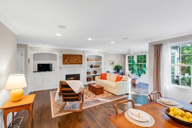 4 Derby Unit B, Salisbury, MA 01952 - living room with crown molding, a glass covered fireplace, dark wood-type flooring, a ceiling fan, and recessed lighting