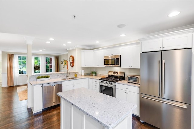 4 Derby Unit B, Salisbury, MA 01952 - kitchen featuring stainless steel appliances, ornamental molding, a peninsula, a center island, and white cabinetry
