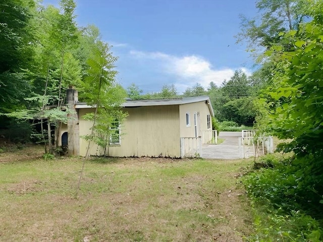 view of side of home with a yard and a wooden deck