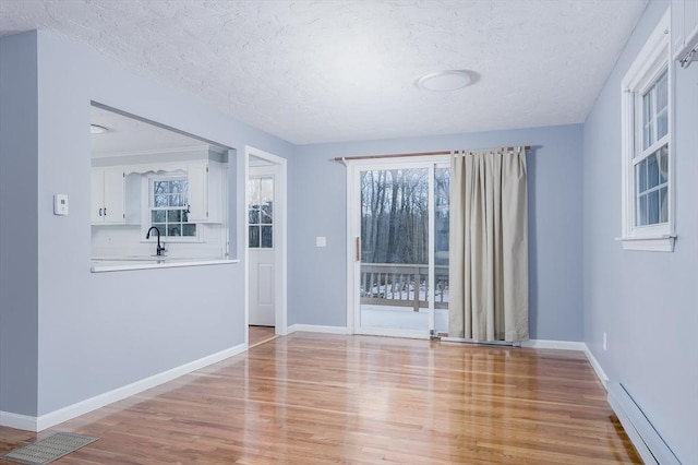 empty room featuring light hardwood / wood-style floors, a textured ceiling, and sink