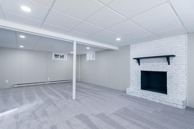 basement featuring baseboard heating, carpet flooring, and a drop ceiling