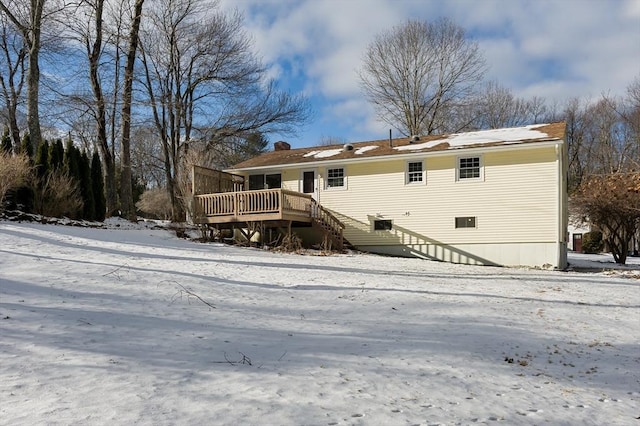 snow covered house featuring a wooden deck