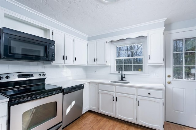 kitchen featuring stainless steel appliances, white cabinetry, sink, and light hardwood / wood-style flooring