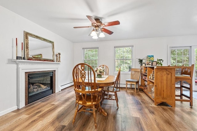 935 Old Keene Rd, Athol, MA 01331 - dining space with wood finished floors, baseboard heating, a ceiling fan, a glass covered fireplace, and a baseboard heating unit