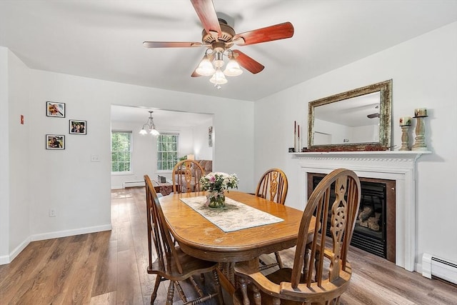 935 Old Keene Rd, Athol, MA 01331 - dining room featuring a baseboard heating unit, wood finished floors, ceiling fan, a glass covered fireplace, and a chandelier