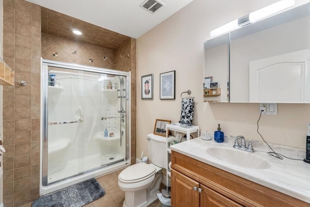 full bath with a shower stall, toilet, vanity, and tile patterned floors
