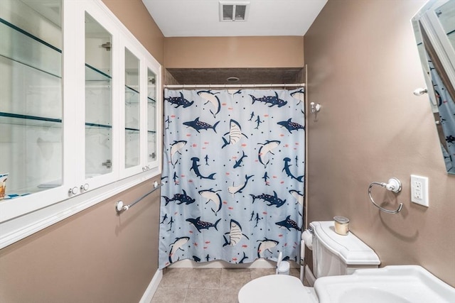bathroom with tile patterned flooring, curtained shower, toilet, and baseboards