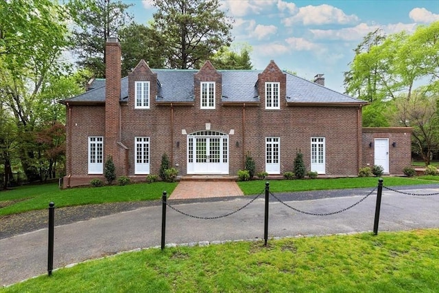 178 Ivy St, Brookline, MA 02446 - view of front of property featuring a chimney, french doors, a front lawn, and brick siding