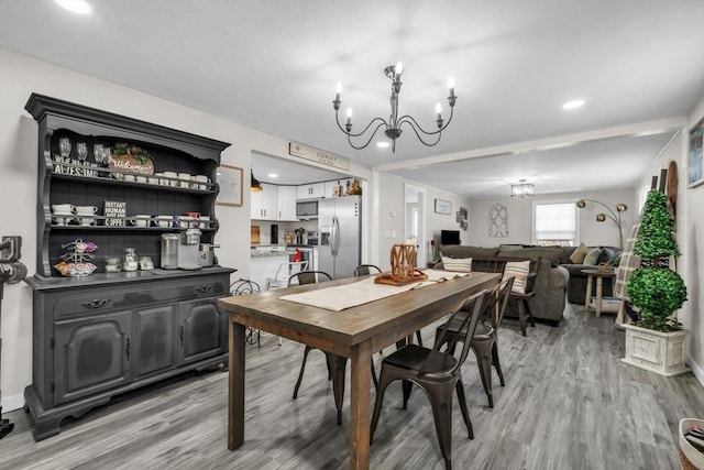 dining area featuring a notable chandelier and light wood-type flooring