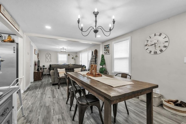 dining space with hardwood / wood-style flooring and a notable chandelier