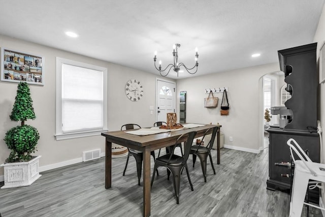 dining room with dark wood-type flooring and a healthy amount of sunlight