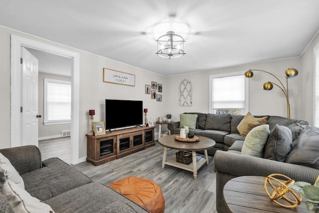 living room with an inviting chandelier and light hardwood / wood-style floors