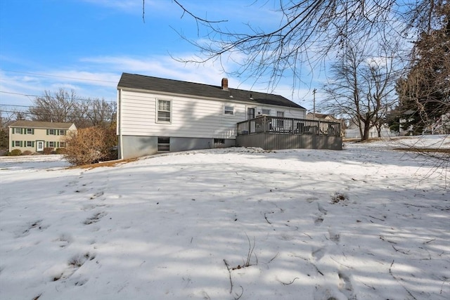 snow covered house featuring a wooden deck