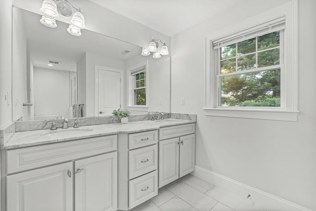 4 Fairfield Pl, Winchester, MA 01890 - bathroom featuring marble finish floors, double vanity, baseboards, and healthy amount of natural light