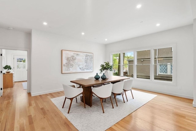 dining area with baseboards, light wood finished floors, and recessed lighting