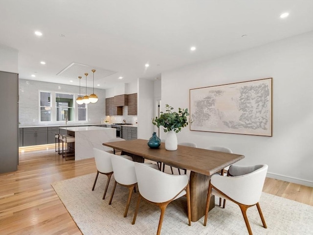 dining space with light wood-type flooring and recessed lighting