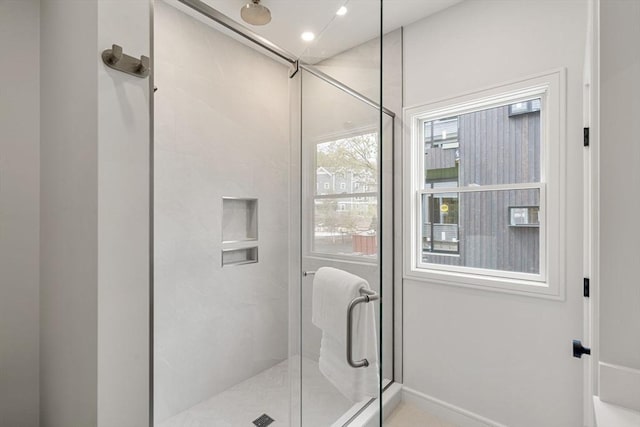 bathroom with baseboards and a shower stall