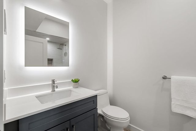 full bathroom featuring toilet, walk in shower, and vanity