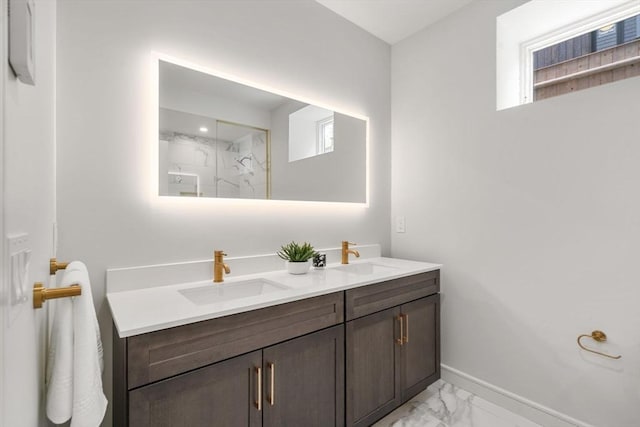 full bathroom with a sink, a marble finish shower, baseboards, and marble finish floor