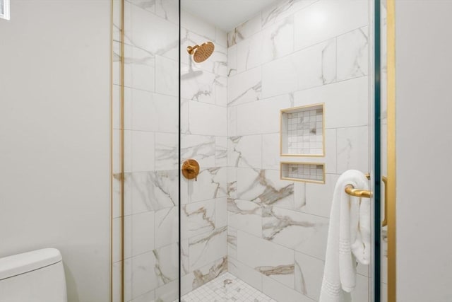bathroom featuring toilet and tiled shower