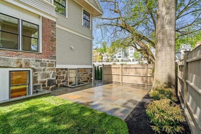 view of yard featuring fence, a patio, and a residential view
