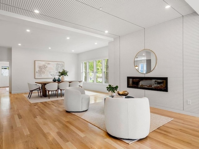 living area featuring a large fireplace, light wood finished floors, and recessed lighting