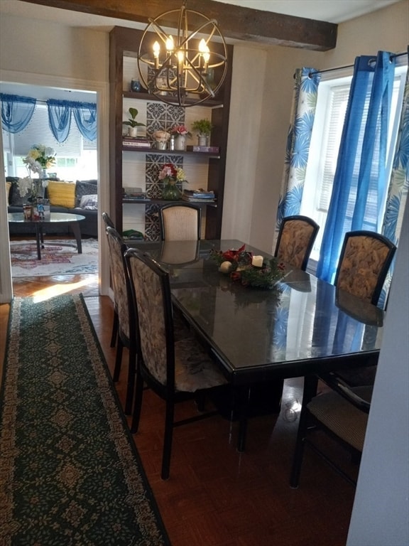 dining room featuring hardwood / wood-style flooring, beam ceiling, a notable chandelier, and plenty of natural light