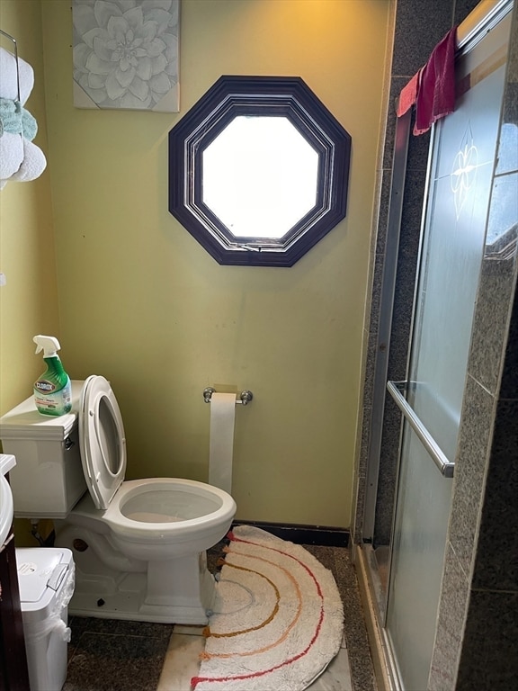 bathroom with toilet and an enclosed shower