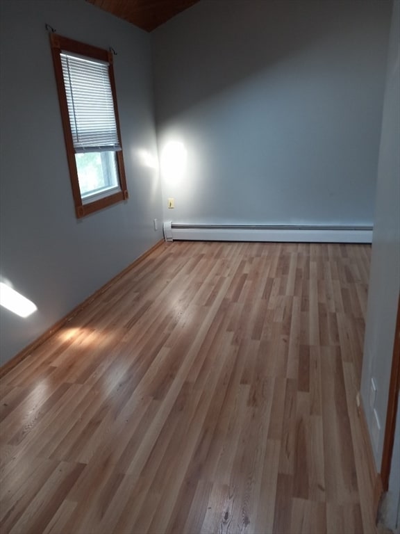 unfurnished room with light hardwood / wood-style floors and a baseboard radiator