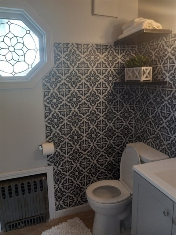 bathroom with vanity, toilet, and radiator