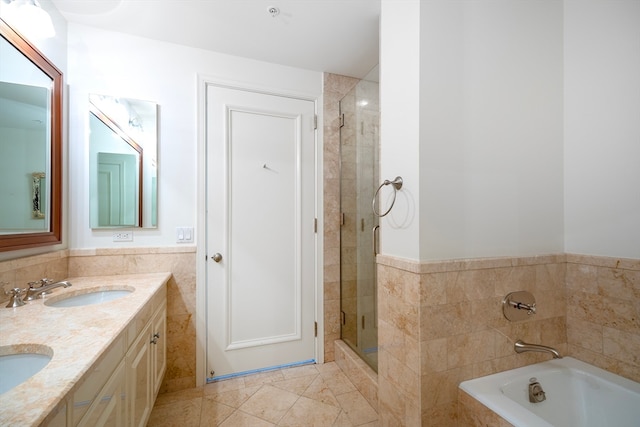 bathroom featuring tile walls, vanity, plus walk in shower, and tile patterned floors