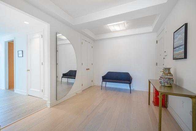 sitting room featuring light hardwood / wood-style flooring and a tray ceiling