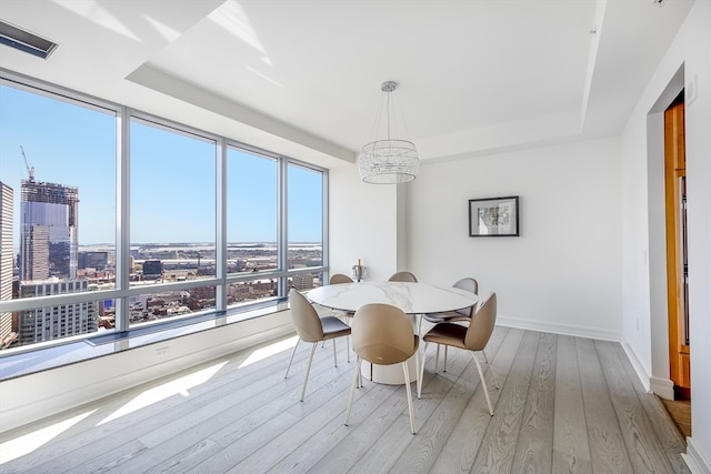 dining area featuring an inviting chandelier and light hardwood / wood-style floors