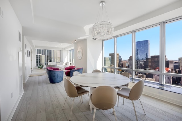 dining space featuring light hardwood / wood-style flooring and a chandelier